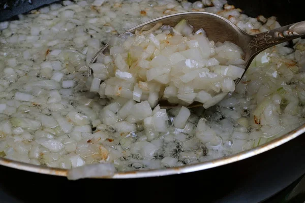 Homemade kitchen. Finely chopped onions are fried in a pan in co — Stock Photo, Image