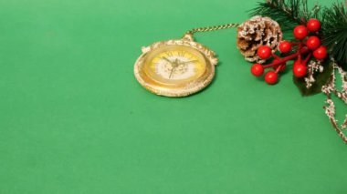 Noel süslemeleri, tatil dekor, çam dalı, çam kozalağı, çilek. İnsan elleri noel hediyesi veriyor. Yeşil arka plan. Kopya alanı. Close.
