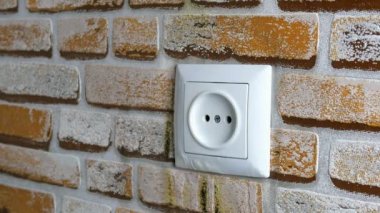 Evde ki duvarda elektrik prizi yanıyor. Kısa devre ve yangın tehlikesi. Belki güç şebekesi aşırı yüklenir veya ekipman kalitesiz olduğu ortaya çıktı. Seçici odak. Close.