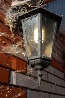 Eski elektrikli fener, örümcek ağları ile büyümüş, tuğla duvar o