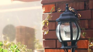 Şehir aydınlatma ekipmanları. Dekoratif elektrikli fener, sokakta tuğla duvarda.