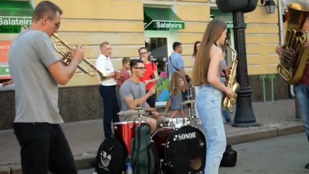 Kiev. Ukrajna. Augusztus 2019:-Street musical banda játszik jazz zenét fúvós hangszerek és teszi a pénzt az élet Podol kerületben a Sagaidachnogo utcában. Kiev, Európa, Ukrajna. — Stock videók