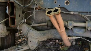 Eski paslı terk edilmiş bir arabanın parçaları. Çeşitli sökülmüş parçalar ve mekanizmalar. Açık havada. Close.