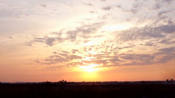 草原や野原の上に日没時に雲と赤とピンクの劇的な空 田園地帯の美しい夕日の空 風光明媚な背景 — ストック動画