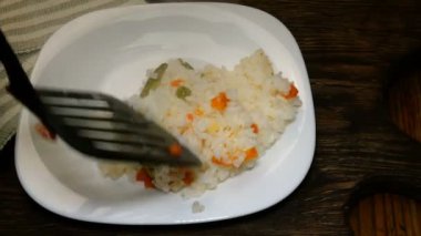 Ev yapımı mutfak. Sıcak haşlanmış pirinç ve doğranmış soğan ile doğranmış domates ahşap mutfak tahtası üzerinde beyaz plaka üzerinde yalan. Iştah açıcı Asya veya Avrupa gıda. Vejetaryen yemekleri. Close.