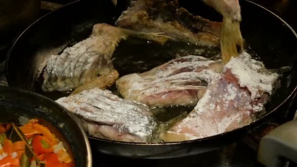 Cocina casera. La carpa de pescado de río, cortada en trozos, se fríe en sartén en aceite de cocina. Primer plano . — Vídeo de stock