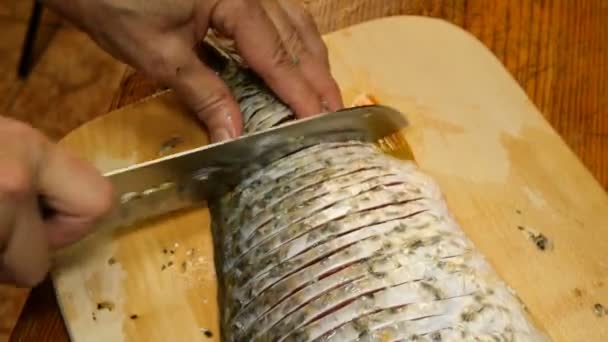 Cucina casalinga. Carpa di pesce di fiume, viene tagliata a pezzi, con coltello da cucina per friggere successiva, sul tagliere sul tavolo della cucina. Primo piano. — Video Stock