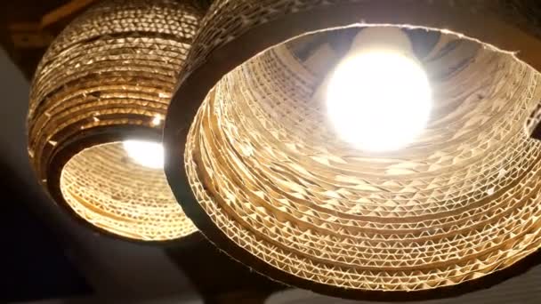 Bruine rieten kroonluchters, met heldere lichtgevende lampen, gloed op het plafond, wuivende licht. Close-up. — Stockvideo