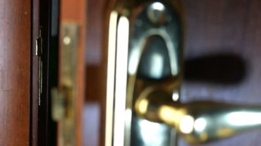 İnsan elleri kapıyı kapatır ve anahtarla kilitler. Kapananı doğrulayacak metal kolu çekti. Yakın plan..