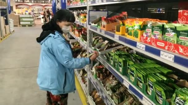 キエフ ウクライナ 2020年5月 医療用マスクの熟女は 流行時にスーパーマーケットの食料品部門の棚に商品を選択Covid 接近中だ — ストック動画