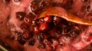 Ev yapımı yemek. Aktif vişne reçeli pişirme videosu. Kirazlı turta hazırlamak ve ahşap kaşıkla karıştırmak. Üstten manzara, üstten aşağı yemek. Yakın plan. Kapalı.