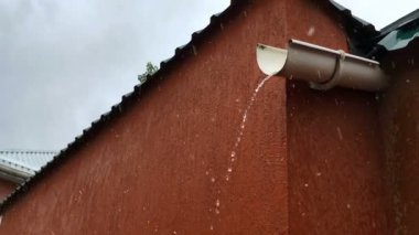 Yağmur sırasında metal drenaj borularından su damlıyor. Yakın plan..