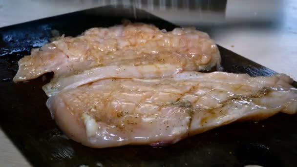 Kuchařská ruka je poražen syrový kuřecí steak s kuchyňským nožem na vaření chutného hovězího steaku. Detailní záběr. — Stock video
