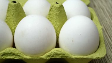 Karton yumurta tepsisinde yemek pişirmek için beyaz tavuk yumurtası. Yavaş çekim Yakın çekim.