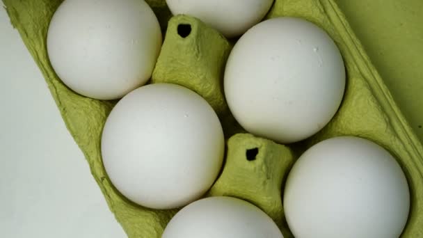 Chefs hand in rubber beschermende handschoenen nemen twee witte kippeneieren uit kartonnen eieren lade voor het koken van het ontbijt. Zelfgemaakt koken. Close-up. — Stockvideo