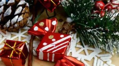 Noel süslemeleri - böğürtlen ve koni ile dekoratif ladin dalları, şekerler, hediyeler, kar taneleri ahşap tezgahta daireler çizer. Noel arkaplanı. Yakın plan. Kapalı.