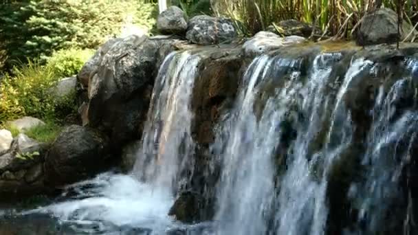 Pequeña cascada con fuertes corrientes que se vierten en el hermoso parque Mezhyhirya en Novi Petrivtsi en Ucrania. Enfoque selectivo. Primer plano. — Vídeos de Stock