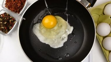 Tavaya tavuk yumurtası dökmek ve kızarmış yumurta pişirmek. Çırpılmış yumurta. Basit bir ev yapımı yemek hazırlama konsepti. Yakın plan..
