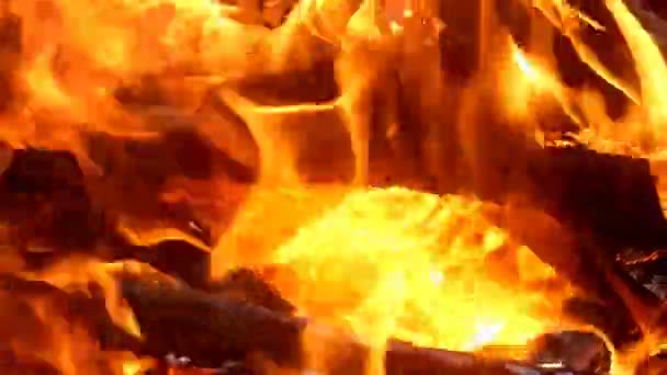 Jasny ogień i płomienie płoną w kominku, ognisku lub grillu. Piękne języki płomieni i gorący blask węgla. Zbliżenie. — Wideo stockowe