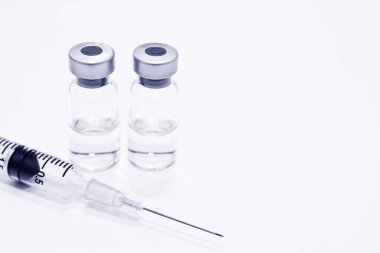 Uyuşturucu veya aşı ve 3 ml plastik şırınga ile izole iğne mavi rengi beyaz arka plan üzerinde şişe