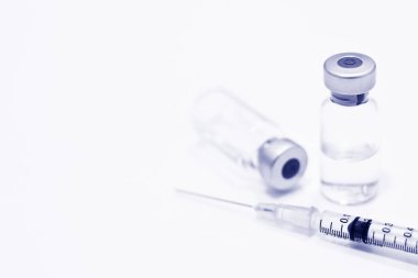 Uyuşturucu veya aşı ve 1 ml plastik şırınga ile izole iğne mavi rengi beyaz arka plan üzerinde şişe
