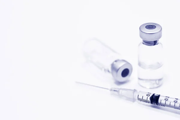 Uyuşturucu veya aşı ve 1 ml plastik şırınga ile izole iğne mavi rengi beyaz arka plan üzerinde şişe