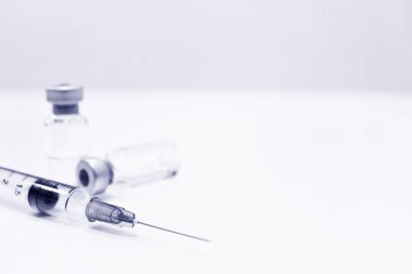 Uyuşturucu veya aşı ve 3 ml plastik şırınga ile izole iğne mavi rengi beyaz arka plan üzerinde şişe