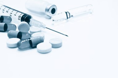 İlaç tablet ve kapsül, şişe ve ampul uyuşturucu ve beyaz arka plan üzerinde izole iğne ile plastik şırınga