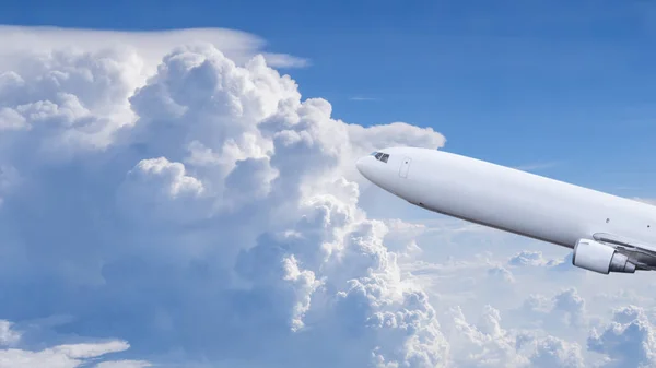青い空と白い雲の下を飛ぶ飛行機 — ストック写真