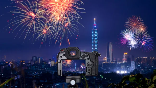 Digital camera over tripod on blur of firework with cityscape night light view of Taipei. Taiwan city skyline at twilight time