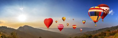 Güneş ışığı, mavi gökyüzü ve beyaz bulut ile renkli sıcak hava balonu Panoraması sinek üzerinde dağ manzaralı Chiangrai, Tayland