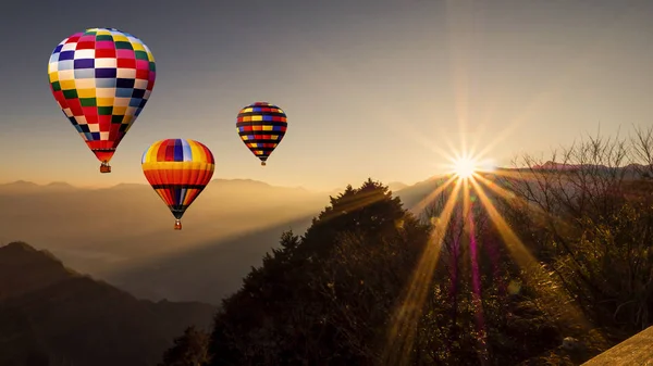Kolorowe gorące powietrze balon latać nad lasem z promieniowaniem słonecznym, w Al — Zdjęcie stockowe