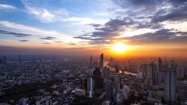 High view of Bangkok cityscape with modern building under blue sky and sunshine in sunset at the evening