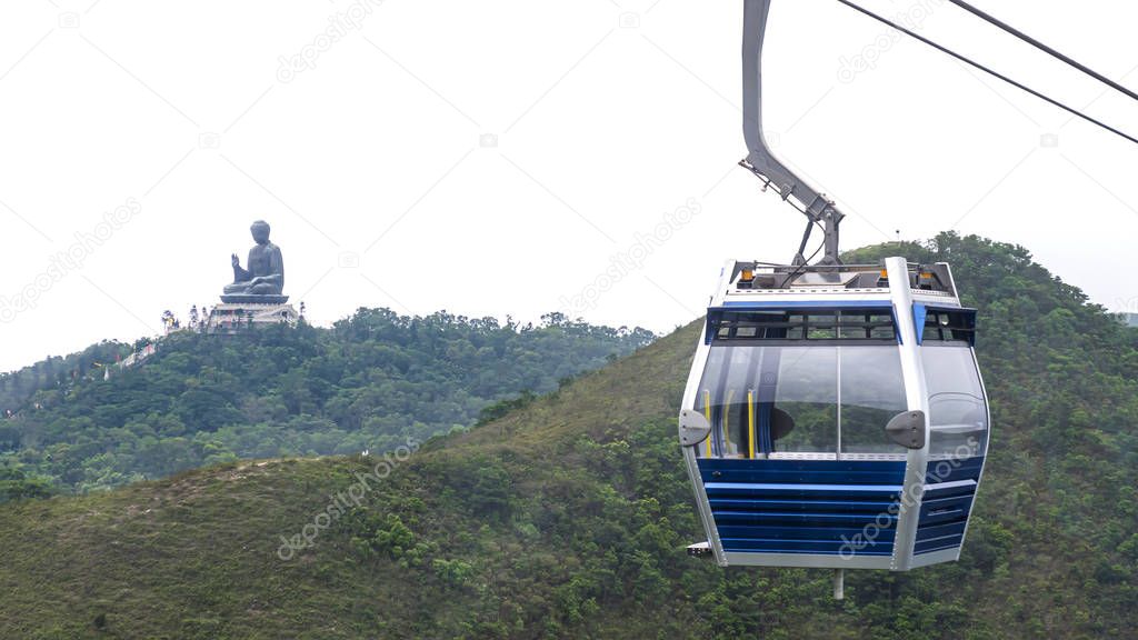 Hong Kong cable car over green mountain with Giant Buddha statue