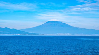 Fuji Dağı 'nın mavi gökyüzü üzerindeki manzarası ve Japonya' nın Shizuoka kentindeki Suruga Körfezi 'ndeki feribot teknesinden gelen beyaz bulut.