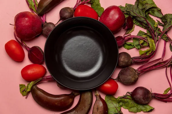 plaka ve domates ve pembe bir arka plan üzerinde beetroots ile muz 