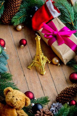 Noel dekorasyonu ve Eyfel Kulesi ile çam kozalakları ve ahşap arka plan üzerinde şube