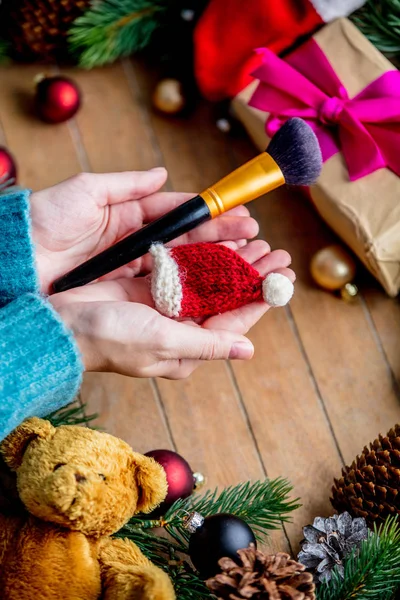 Manos Femeninas Sosteniendo Cepillo Maquillaje Fondo Con Juguete Navidad Bolas —  Fotos de Stock