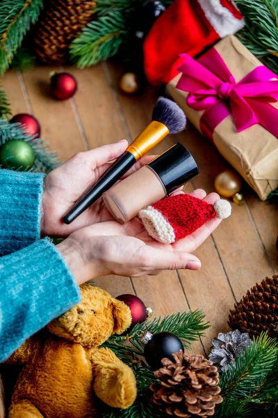 Manos Femeninas Sosteniendo Cepillo Maquillaje Fundación Fondo Con Juguete Navidad —  Fotos de Stock