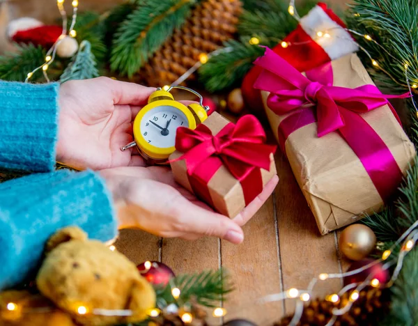 Manos Femeninas Sosteniendo Una Caja Regalo Reloj Despertador Fondo Decorado —  Fotos de Stock