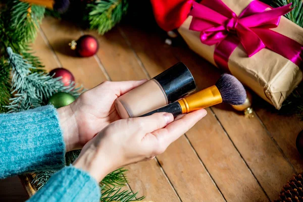 Mãos Femininas Segurando Escova Maquiagem Fundação Fundo Com Brinquedo Natal — Fotografia de Stock