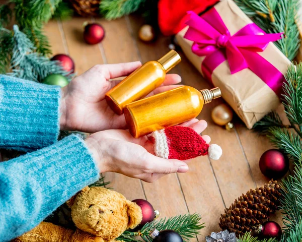 Manos Femeninas Sosteniendo Frasco Perfume Fondo Con Juguete Navidad Bolas —  Fotos de Stock