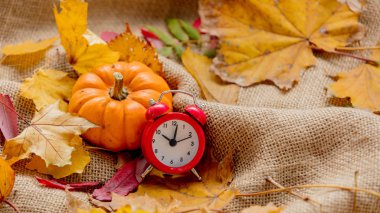 Turuncu kabak ve çalar saat ile yapraklarda buruşuk tutuyordu. Sonbahar sezonu zaman