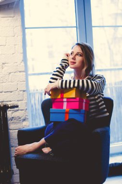 güzel kızıl saçlı kız koltukta oturan hediye kutuları ile