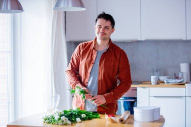 Evde mutfakta çalışan genç adam çiçekçi. Kendi iş kavramı