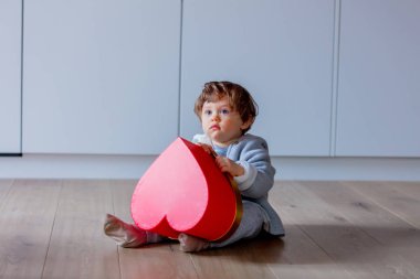 Küçük Sevgililer kalp şekli kutu ile katta oturan oğlu. 