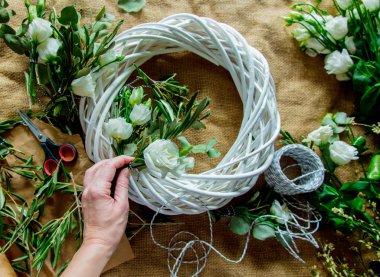 Çul arka plan üzerinde beyaz gül çelenk oluşturma kadın görünümünü kırpılmış.