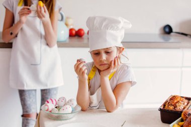 Paskalya yumurtaları mutfak at ile Şef giysili iki genç kız.