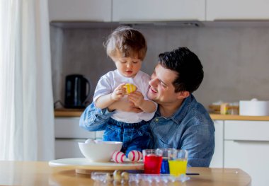 Genç Baba ve çocuk Paskalya tatili ve resim yumurta için hazırlamak 