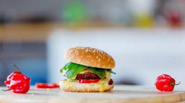 Hambuerger görüntülemek ve ahşap zemin üzerine biber. Yan görünüm 